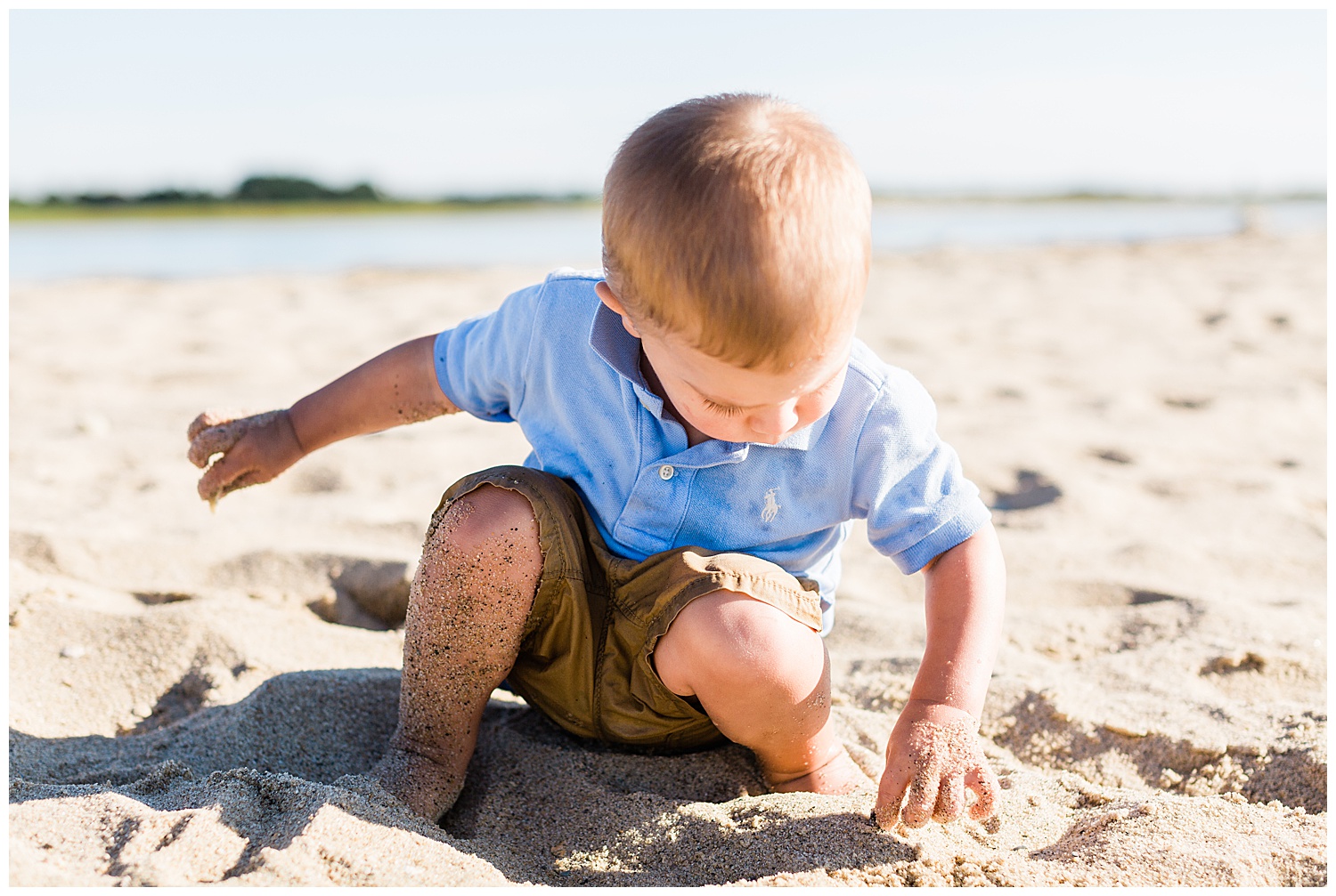 sandy toddler playing on beach