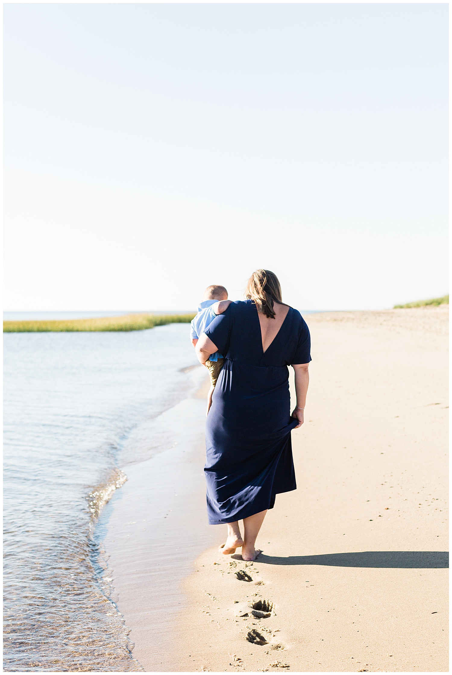 mother carrying son on beach in cape cod