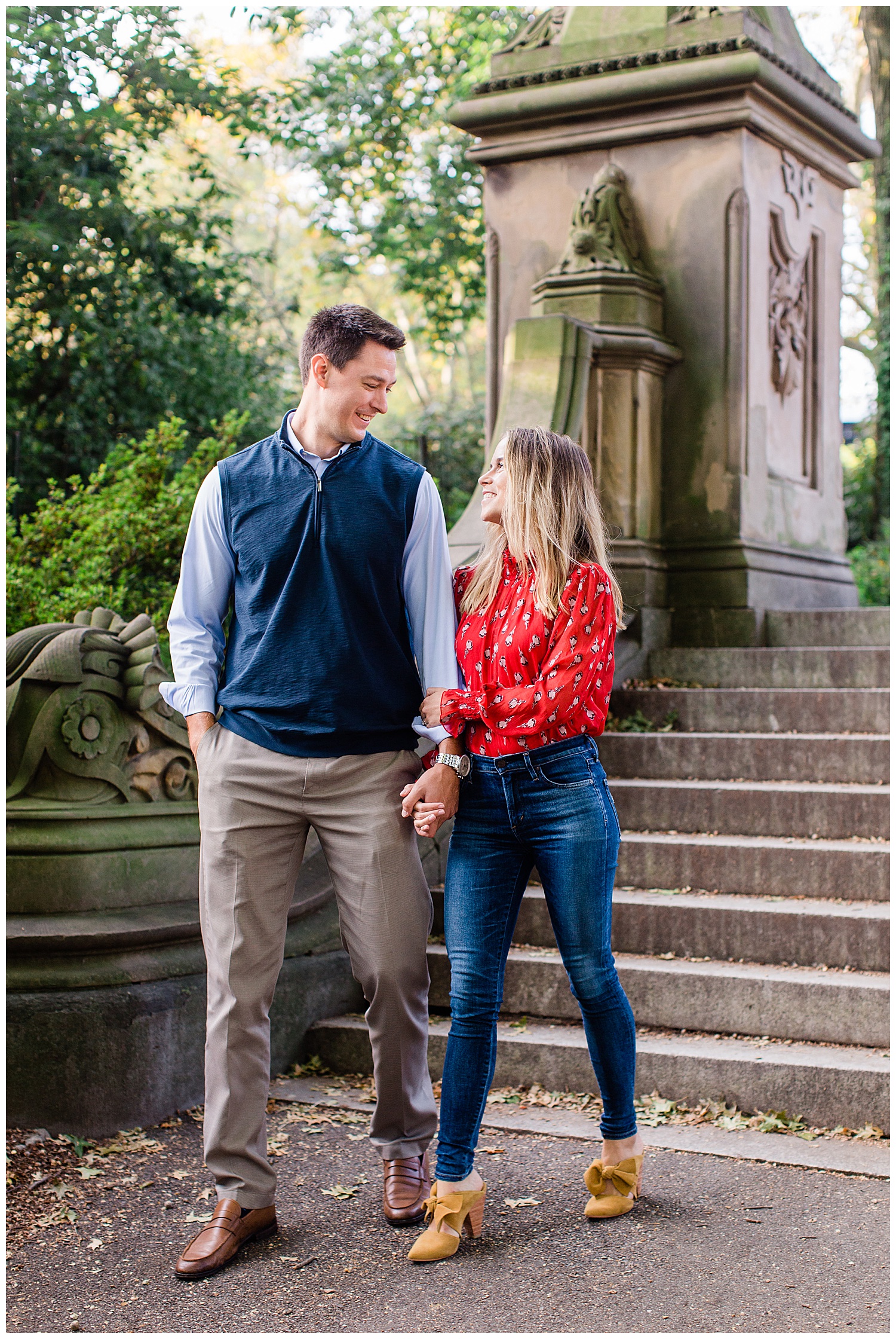 Couple holds hands while walking through Central Park