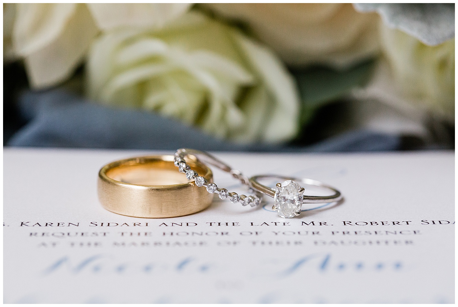 gold wedding band and wedding rings on white invitations