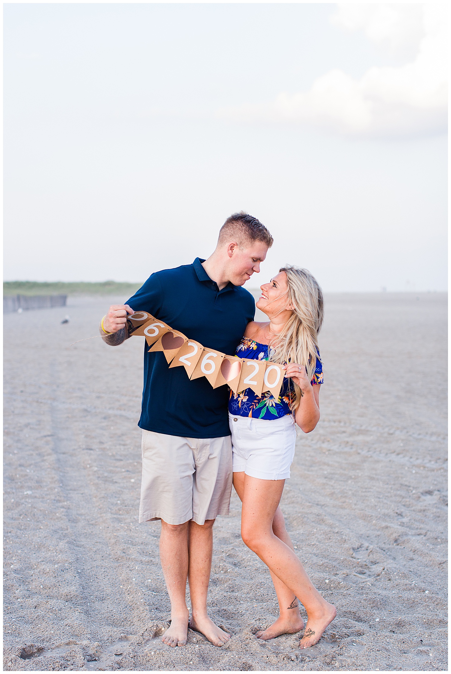 Couple holds date flag on beach