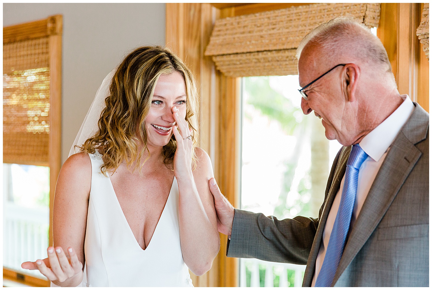 bride wiping tears after seeing father on her wedding day