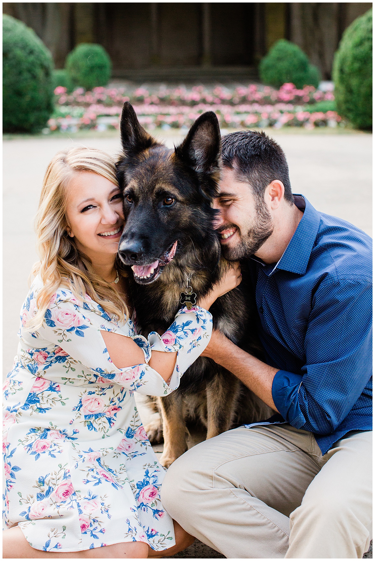 Couple snuggle their dog while laughing together